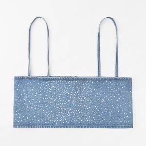 Top made of denim. Straight neckline and spaghetti straps. Metal hook closure